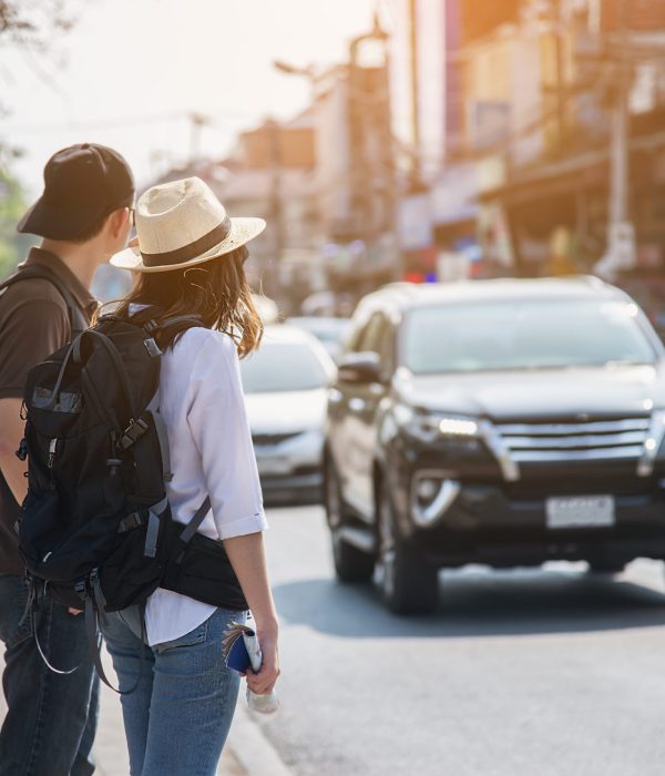 Asian backpack couple tourist holding city map crossing the road - travel people vacation lifestyle concept